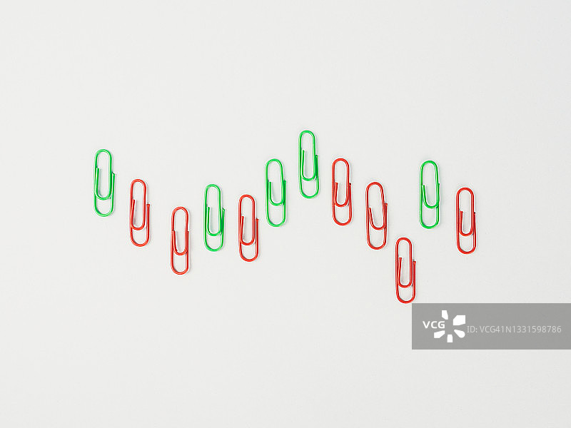 用回形针制作的日式K线图，隔离在亮蓝色背景上图片素材