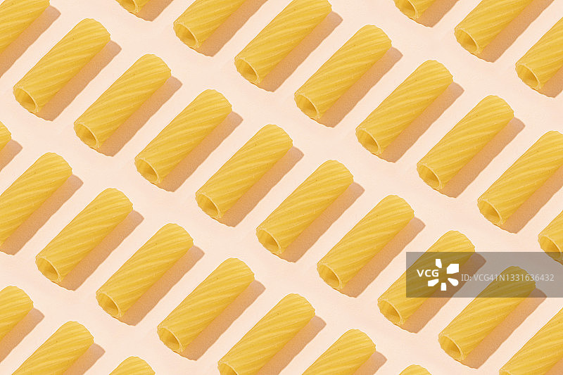 粉色背景上的 tortiglioni 意大利面图片素材