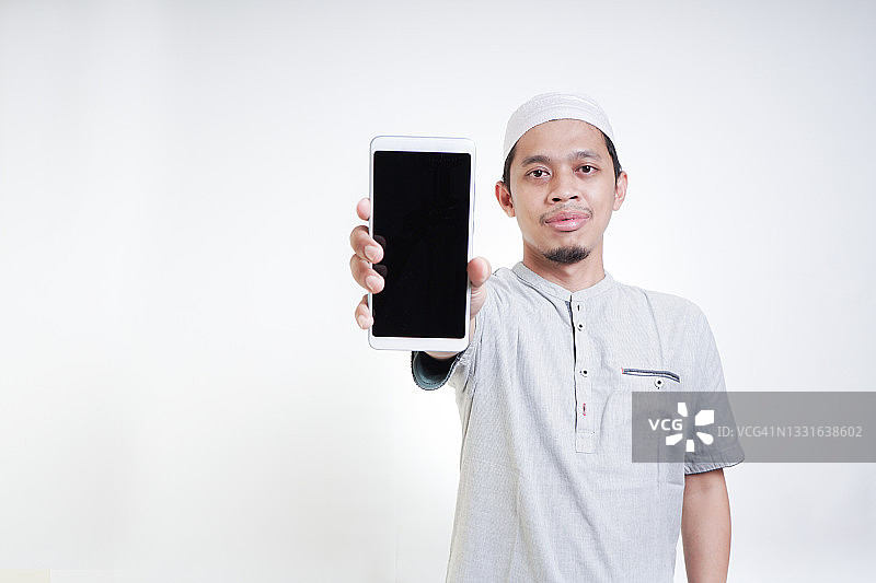 展示智能手机空白屏幕的亚洲穆斯林青年图片素材