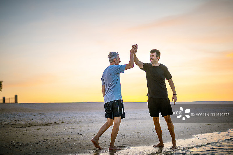 在海滩上奔跑的男人，享受健康生活和夏季假期图片素材