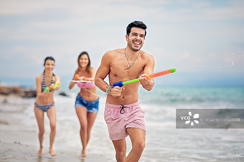 朋友们在海滩上玩水枪图片素材