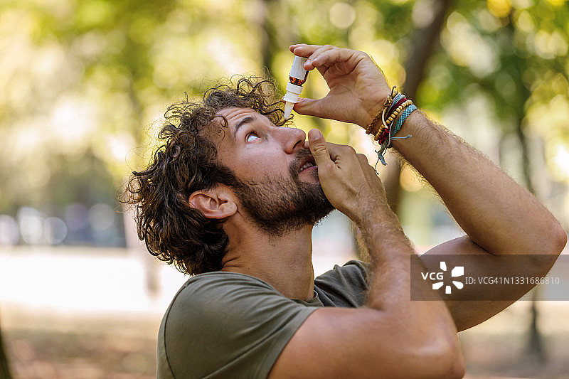 患有眼疾的中年男人在户外滴眼药水图片素材