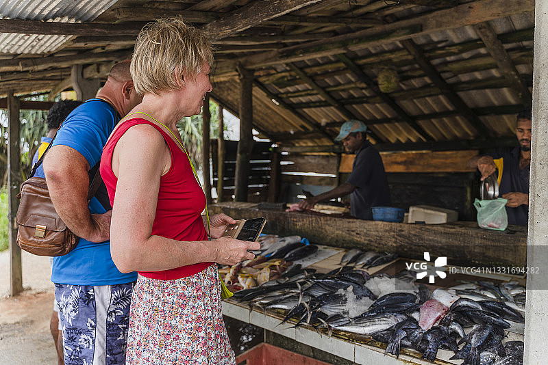 在斯里兰卡小街市上购买鲜鱼的欧洲游客图片素材