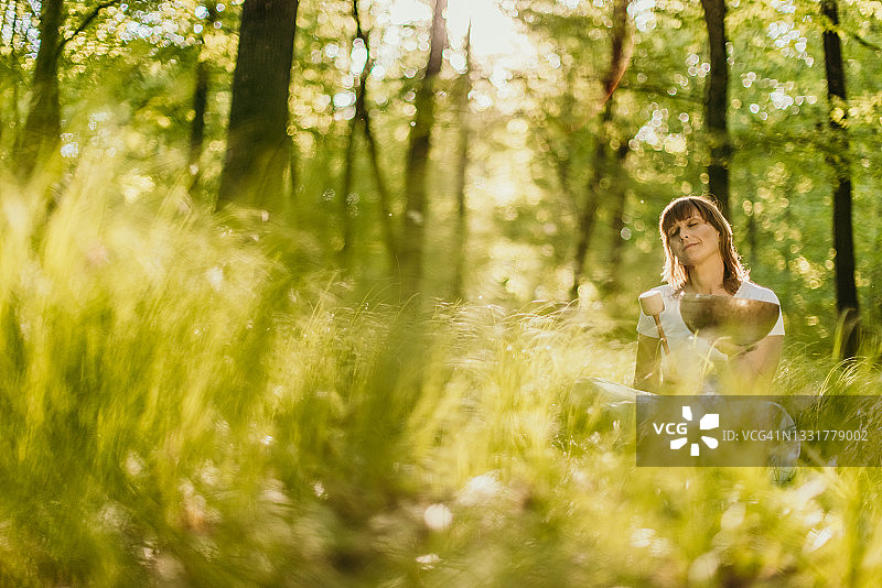 女人在森林里使用磬图片素材