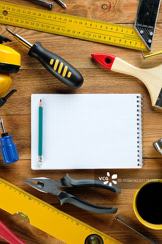 茶或咖啡杯与建筑工具：木桌上的工作休息图片素材