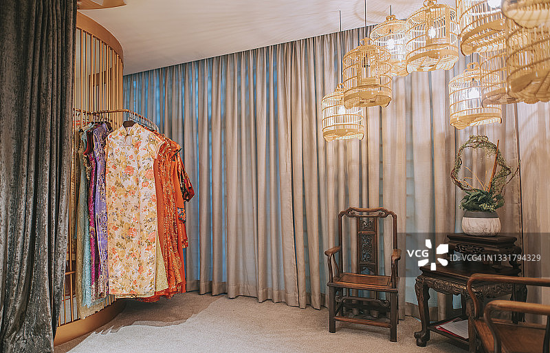 复古风中式旗袍店内部：鸟笼装饰，角落里的古董木椅图片素材