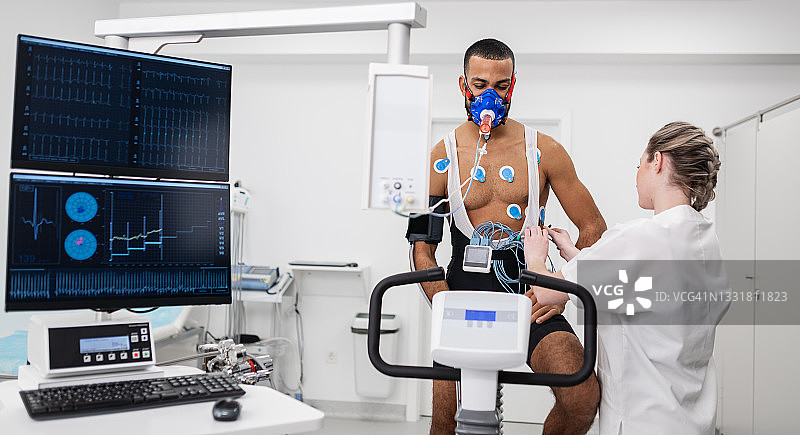 男人在室内自行车上进行心电图和VO2测试图片素材