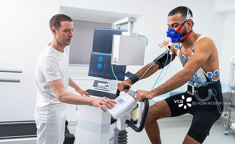 男人在室内自行车上进行心电图和VO2测试图片素材