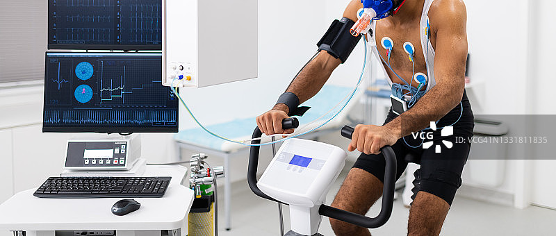 男人在室内自行车上进行心电图和VO2测试图片素材