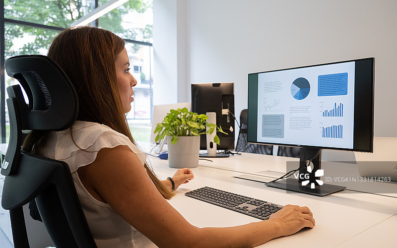 在办公室使用电脑的西班牙裔女人图片素材