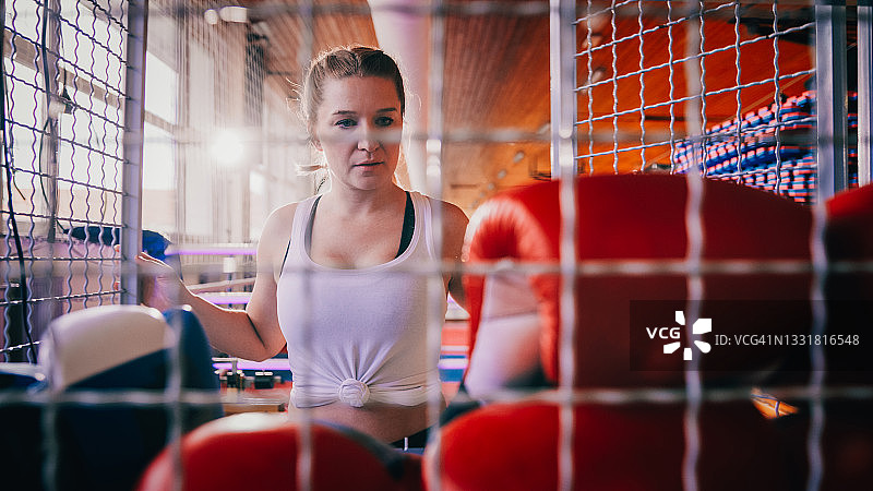女人看着装备箱里的拳击手套图片素材