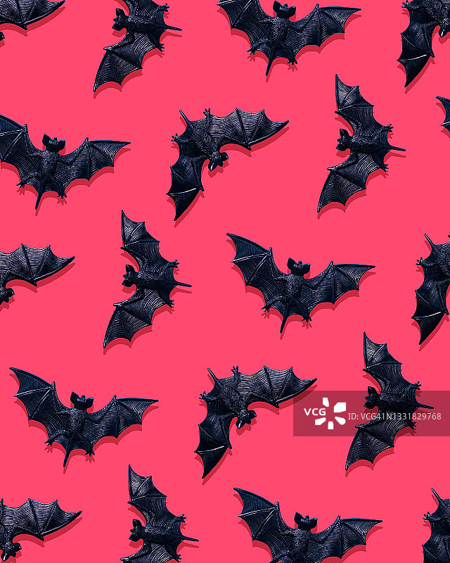 粉色背景上的塑料蝙蝠玩具图片素材