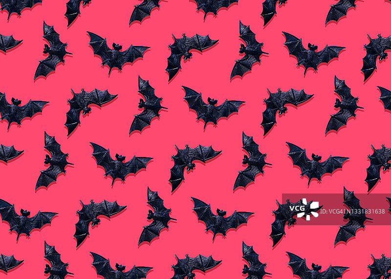 粉色背景上的塑料蝙蝠玩具图片素材