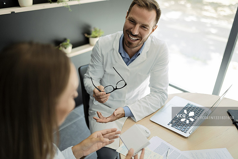 年轻医生在办公室与病人交谈解释图片素材