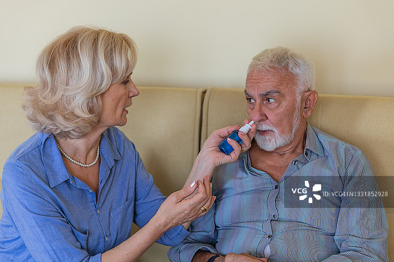 一位老人在接受他细心妻子的医疗救助图片素材