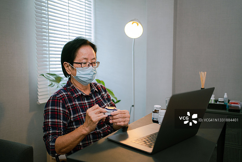 妇女使用脉搏血氧仪和笔记本电脑，测量氧饱和度图片素材