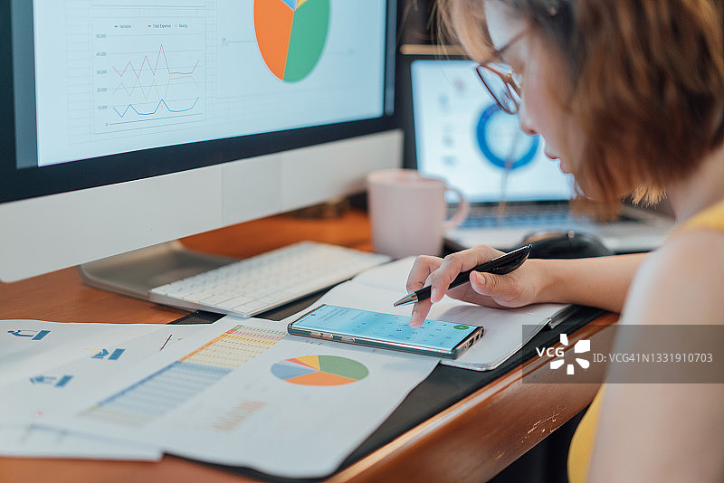 亚裔女性在家计算开支和规划预算图片素材