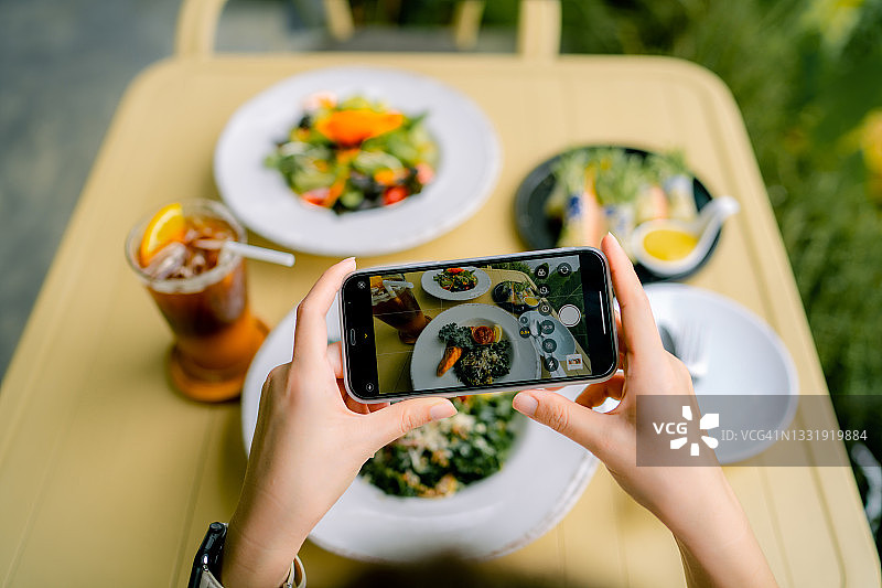 快乐的女人在社交网络上分享健康食物照片图片素材