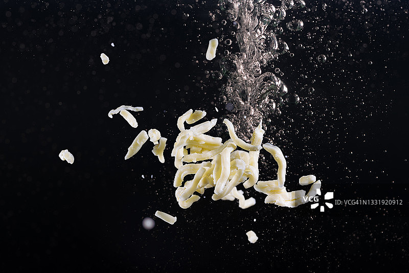 高速同步拍摄的马苏里拉奶酪丝图片素材