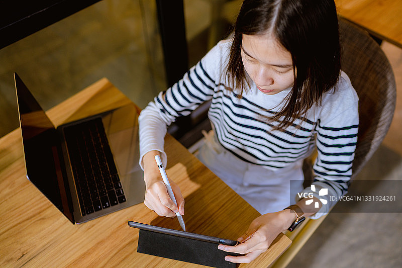 在咖啡店用笔记本电脑进行设计的设计师图片素材