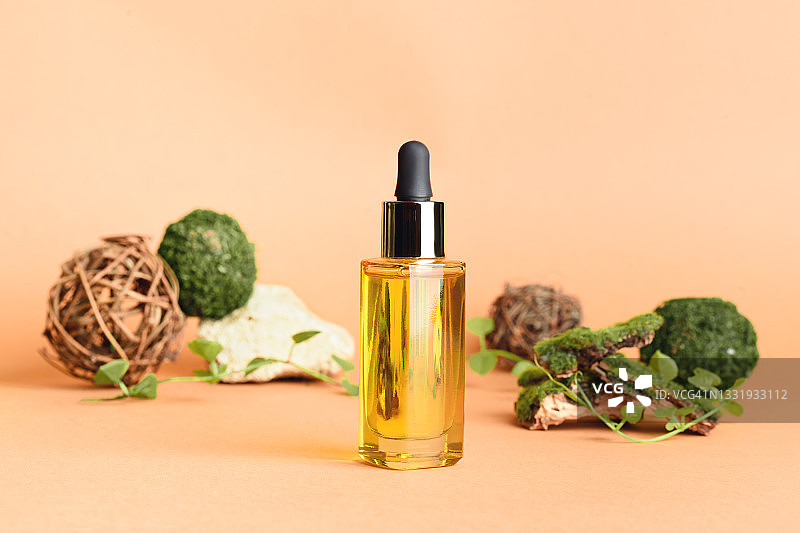带苔藓和其他天然装饰物的滴管精华液玻璃瓶图片素材