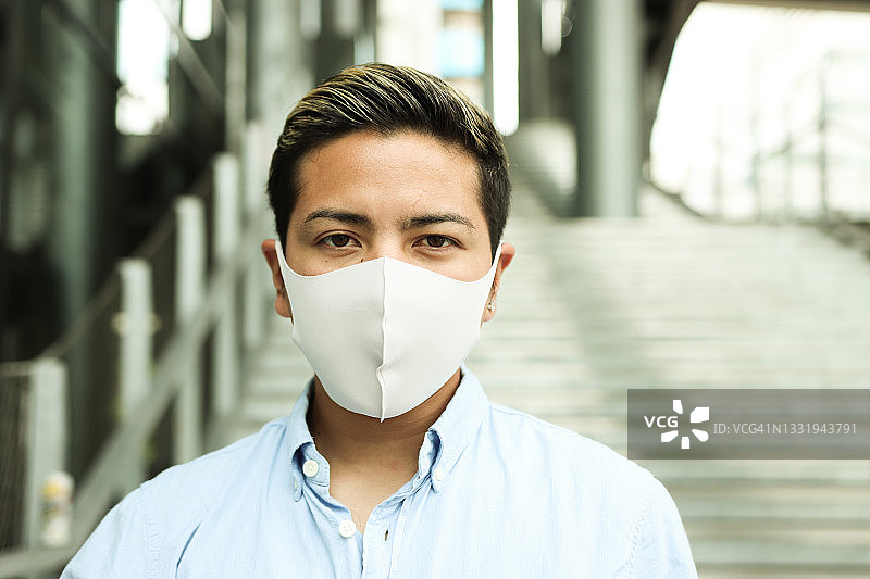 戴防护口罩的年轻拉丁男人肖像图片素材