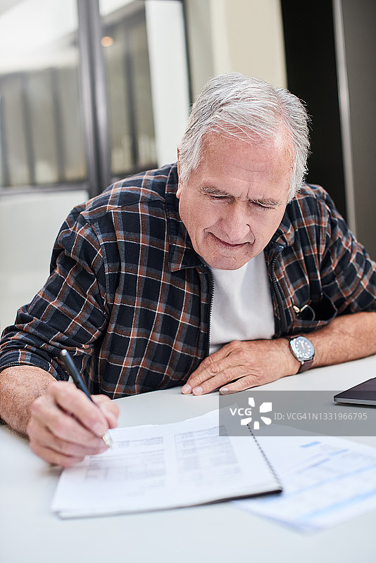 年长的男人在家处理文件图片素材