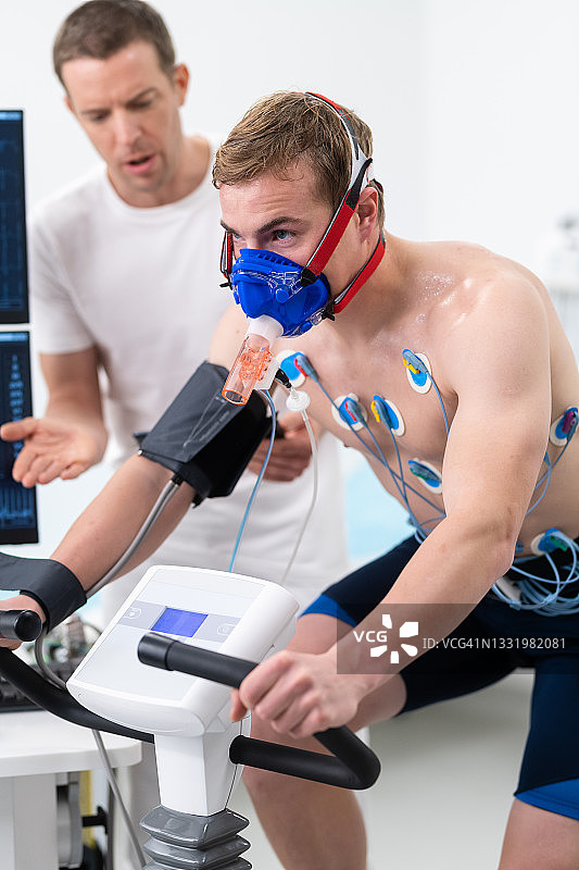 男人在室内自行车上进行心电图和VO2测试图片素材