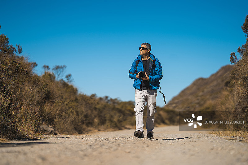 摄影师在冬季的自然小径上拍摄图片素材