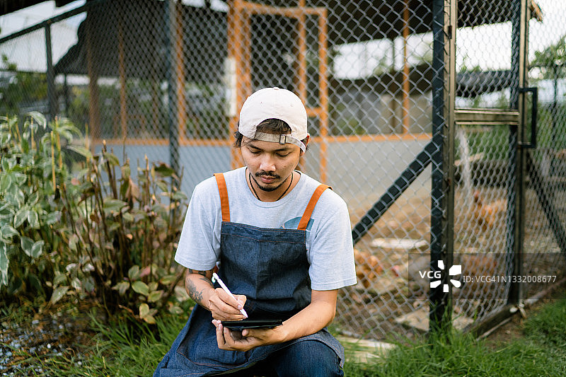 亚洲园丁使用平板电脑，享受舒适现代的园艺生活图片素材