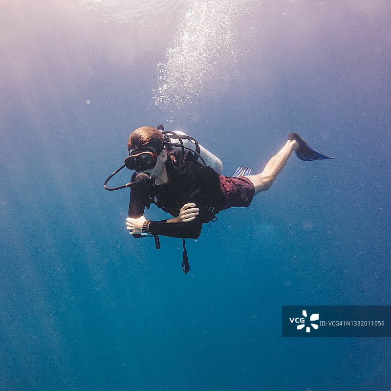 透过蓝色水域看到的潜水员的水下景观图片素材