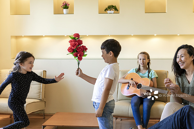 一家人在生日派对上享受欢乐，聆听女孩弹吉他图片素材