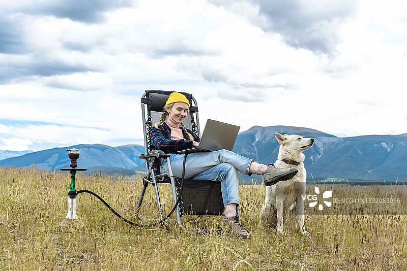 在山上度假时用笔记本电脑工作的年轻女商人图片素材