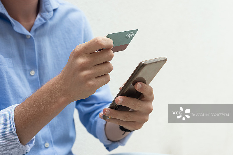 男人用手机和信用卡在线购物图片素材