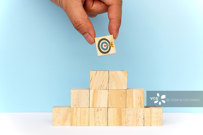 手部选择木制积木金字塔顶部的目标图片素材