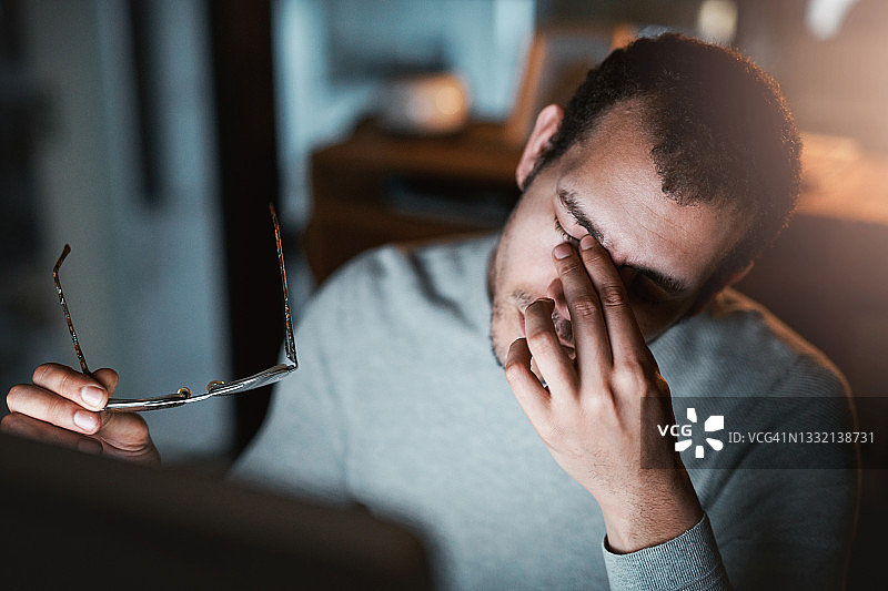 疲惫的年轻男人晚上在办公室使用电脑的特写镜头图片素材