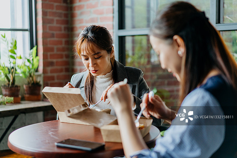 和同事一起吃外卖午餐的亚洲女商人图片素材