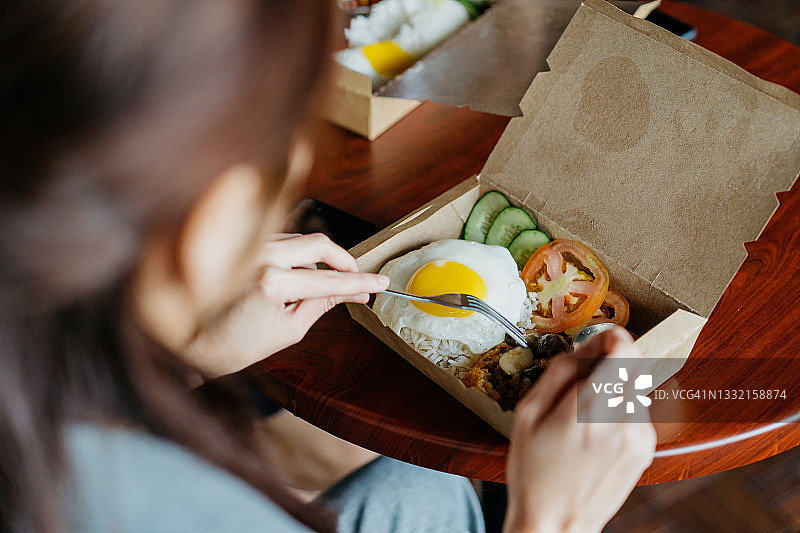 亚洲女人午休时吃外卖盒饭图片素材