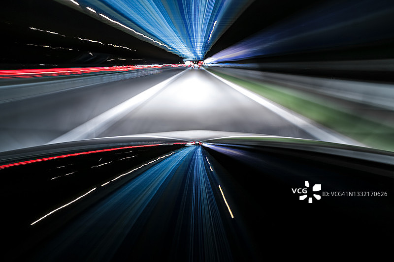 夜间在德国高速公路上飞驰的闪亮黑色电动汽车图片素材