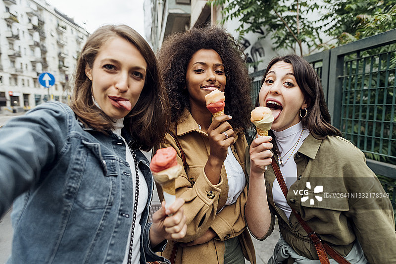 拿着冰淇淋与朋友自拍的女人图片素材