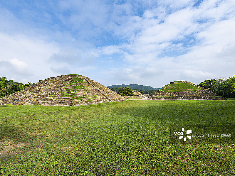 墨西哥韦拉克鲁斯El Tajin考古遗址的草地景观上的金字塔图片素材