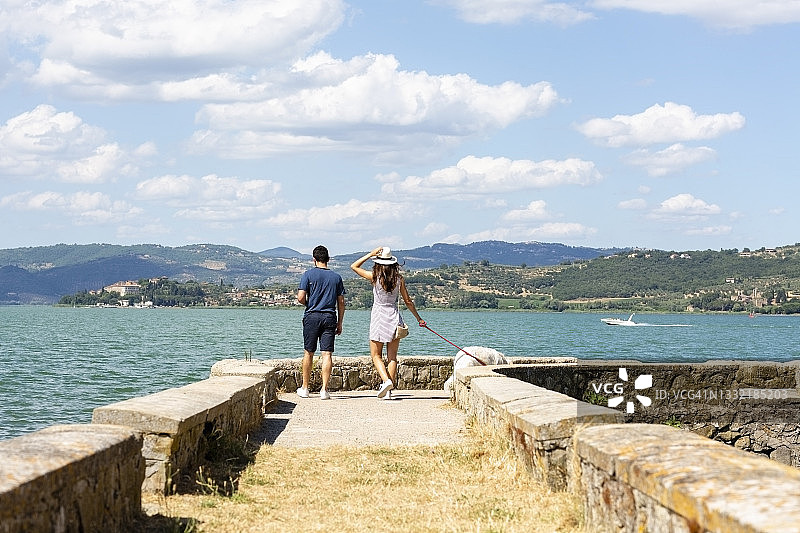游客情侣在码头上遛狗图片素材