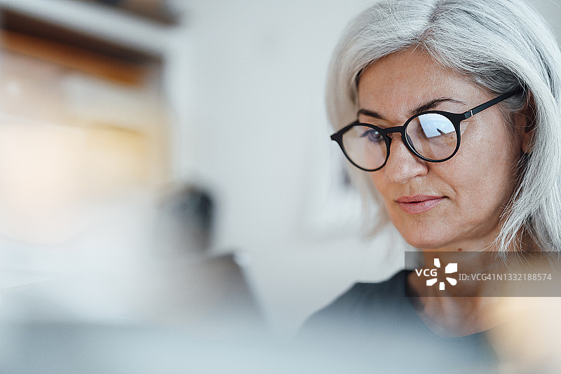 戴眼镜的女商人正在办公室工作图片素材