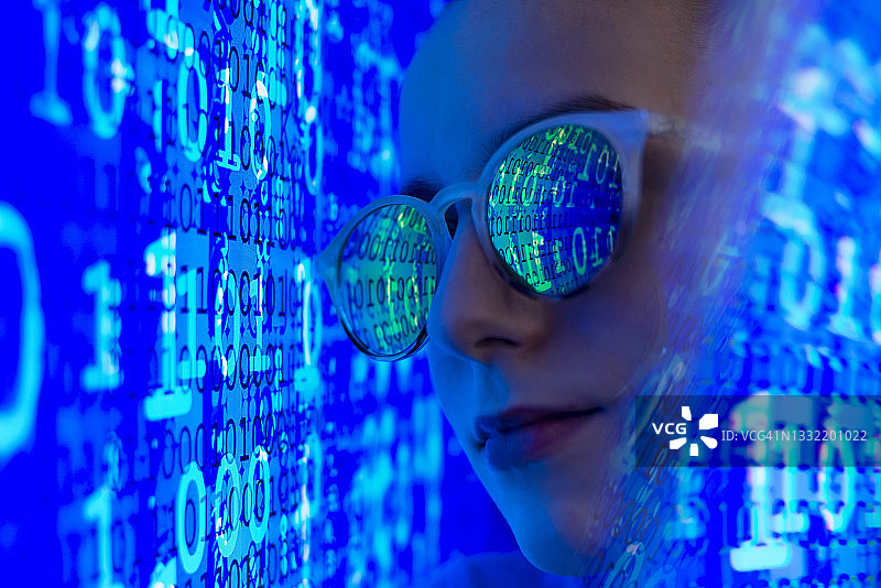 正在电脑设备上检查二进制代码的女性网络罪犯图片素材