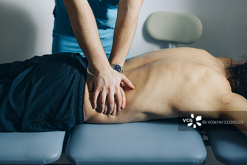 理疗：脊椎按摩师为患者进行背部按摩图片素材
