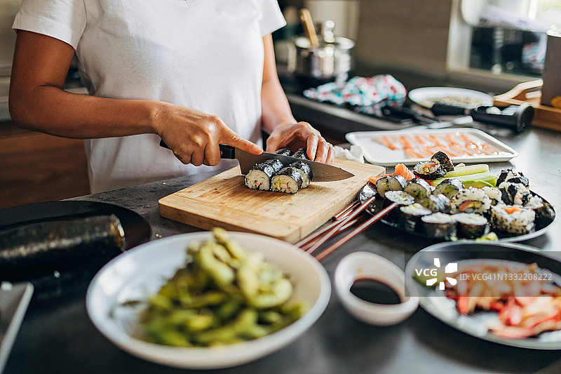 熟练的泰国女寿司厨师正在切寿司卷图片素材