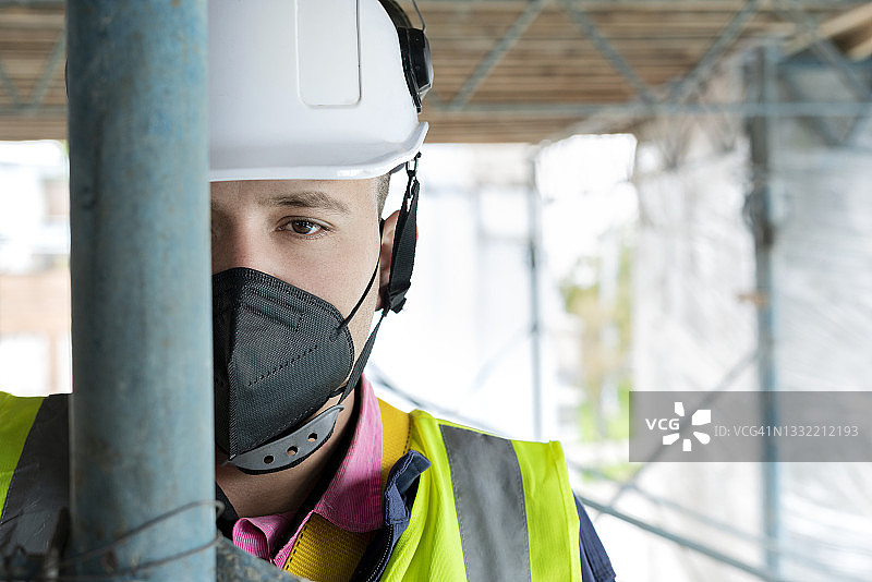 负责建筑的拉丁裔男子在工作中，佩戴安全装备并看向镜头图片素材