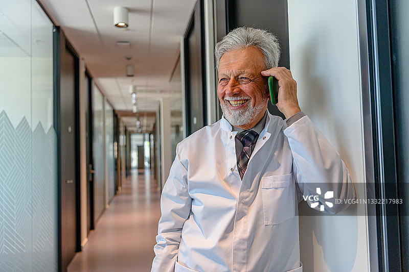 年长的医生在医疗诊所打电话图片素材