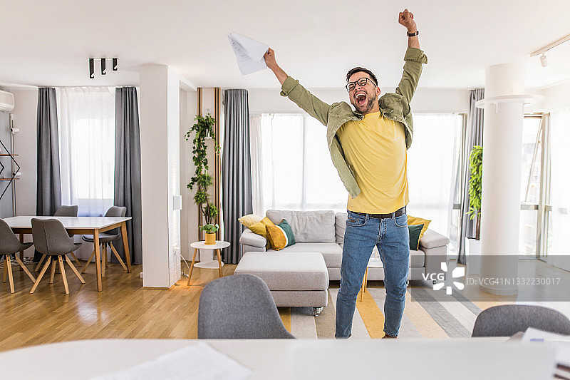 快乐的年轻人拿着文件并庆祝图片素材