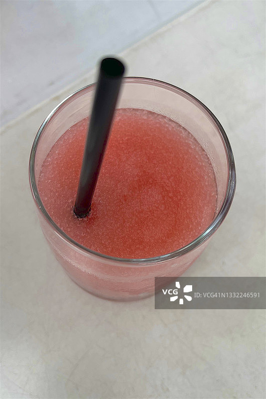 俯视玻璃杯中带吸管的冰镇玫瑰酒图片素材